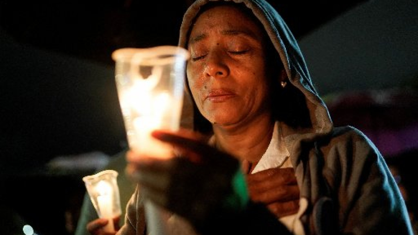 A woman prays as she attends a candlelight vigil in Cali, Colombia, Aug. 17, 2026, in memory of the victims of the earthquake. Priests from the Archdiocese of Bogota, led by their bishop, Cardinal Luis José Rueda Aparicio, embarked on a five-day mission to provide spiritual assistance to people living in cities affected by the Aug. 10 earthquake. (OSV News photo/Sergio Acero, Reuters)