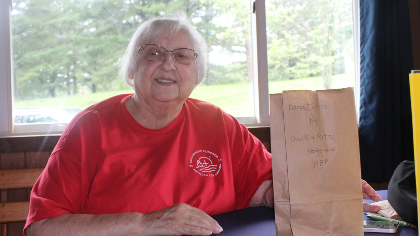 Smiling as she works, volunteer Sandy Butler helps set up on Aug. 11 at Camp Lawrence in Valparaiso for the Diocese of Gary Priests’ Picnic, which had to be moved from Aug. 12 to Aug. 19 due to the damaging storm that moved through Northwest Indiana as the work continued. Butler will receive this year’s Diocese of Gary Guardian Angel Award at the Vocations Office’s Black Tie, White Collar Gala on Sept. 18. (Marlene A. Zloza photo)