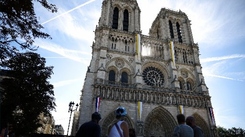 People look at the Notre Dame Cathedral decorated with Vatican flags in Paris Sept. 23, 2026, as preparations continue ahead of Pope Leo XIV's Sept. 25-28 visit to France, (OSV News photo/Sarah Meyssonnier, Reuters)