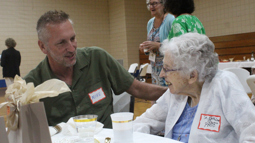 Mike Montgomery of the Serra Club talks with nonagenarian Sister Kathleen Quinn of the Poor Handmaids of Jesus Christ during the annual luncheon hosted by the club for Diocese of Gary religious sisters. The meal, along with games, prizes and gift bags, was held at St. Bridget in Hobart on Sept. 12. (Marlene A. Zloza photo)
