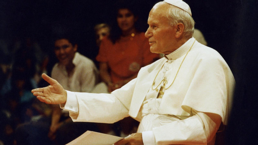 St. John Paul II answers questions from young people during a 1987 teleconference in Los Angeles. His feast day is Oct. 22. (OSV News photo/Joe Rimkus Jr.)