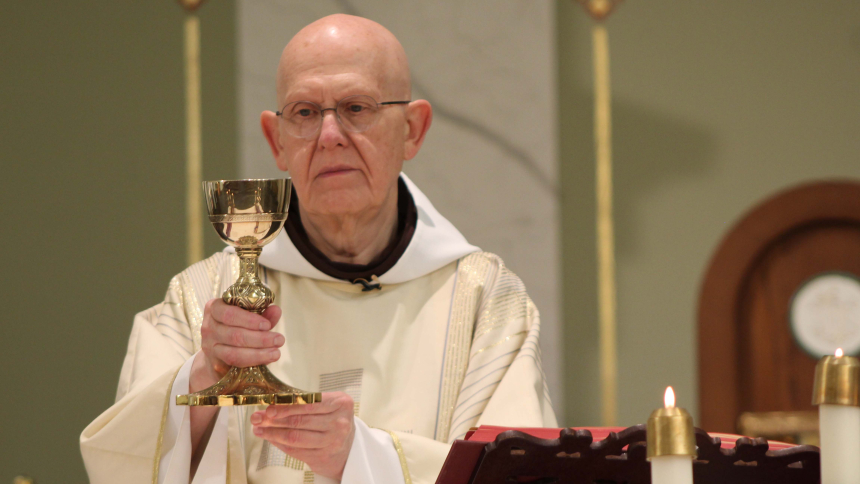 Raising the chalice, Father Patrick Gawrylewski, O.F.M., consecrates the Precious Blood during morning Mass on Oct. 2 at Holy Name of Jesus in Cedar Lake, where he has served as administrator for five years. The Franciscan priest is celebrating 50 years since his ordination in Wisconsin, his home state. (Marlene A. Zloza photo)