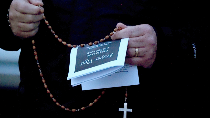 A member of the group taking part in the rosary/prayer service clings to his rosary while praying on the eve of the execution of Benjamin Donnie Ritchie at Indiana State Prison. (Deacon Bob Wellinski photo)
