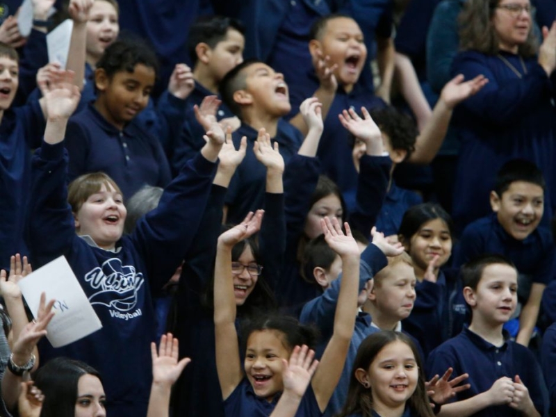 Children cheering catholic schools receive gift