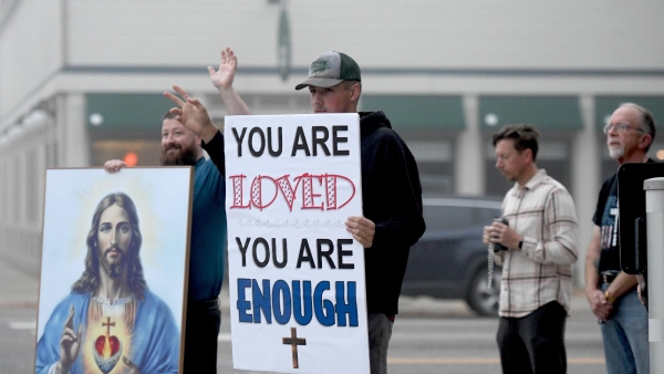 Will Threlkeld, left, and Isaac Eggerth greet passersby with a wave and a smile on a street corner in downtown Little Falls, Minn., Sept. 22, 2025. (OSV News photo/Dianne Towalski, The Central Minnesota Catholic)